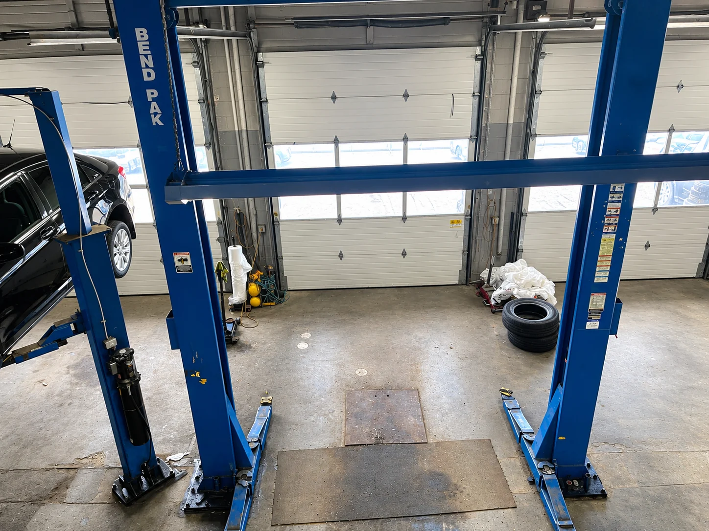 Blue two-post vehicle lifts in an Elite Autoworks service bay