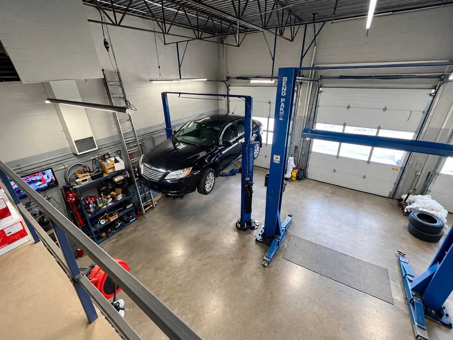 Elite Autoworks workshop with a sedan between two vehicle lifts