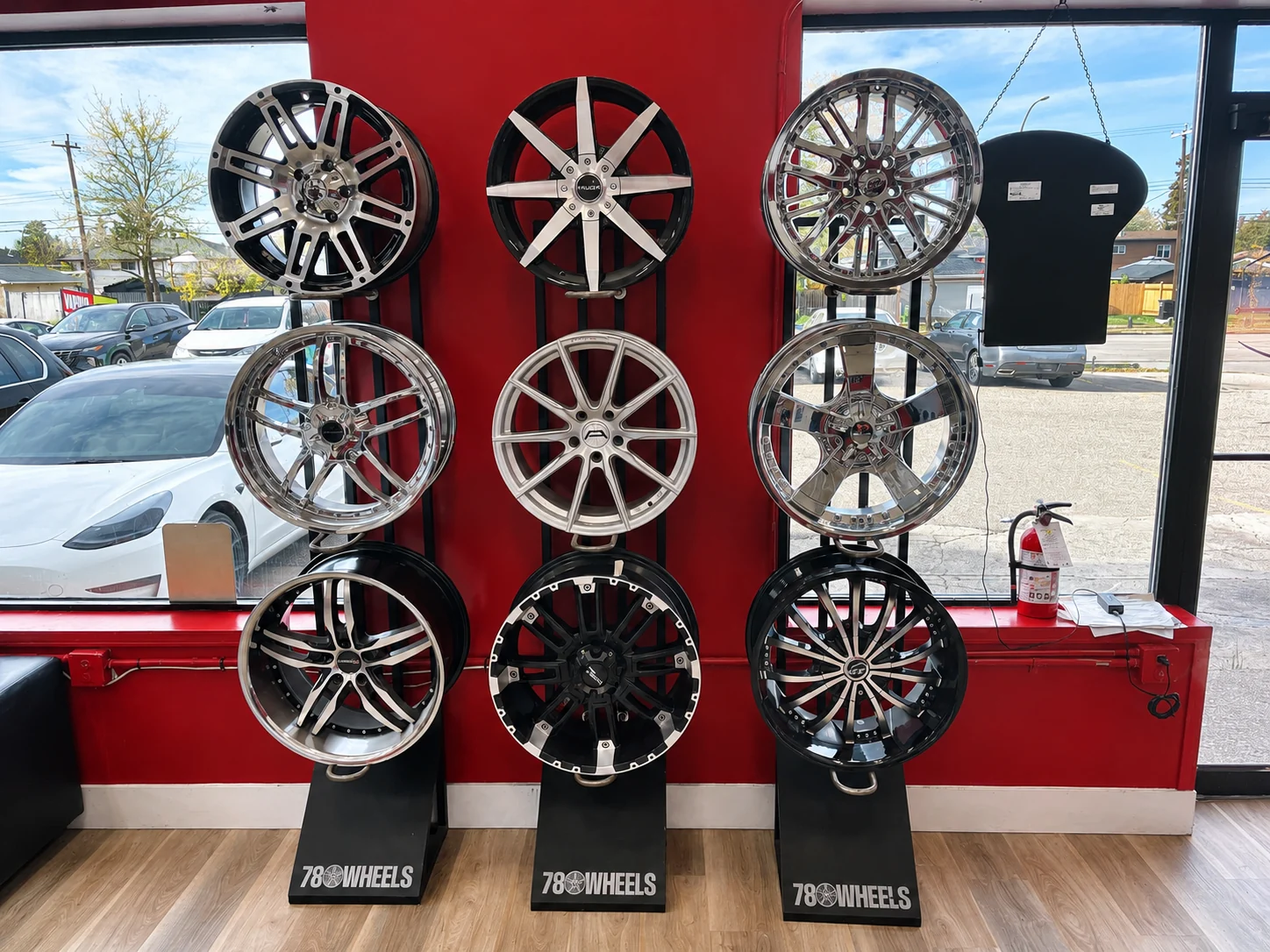 Chrome and alloy wheels on display stands by the window